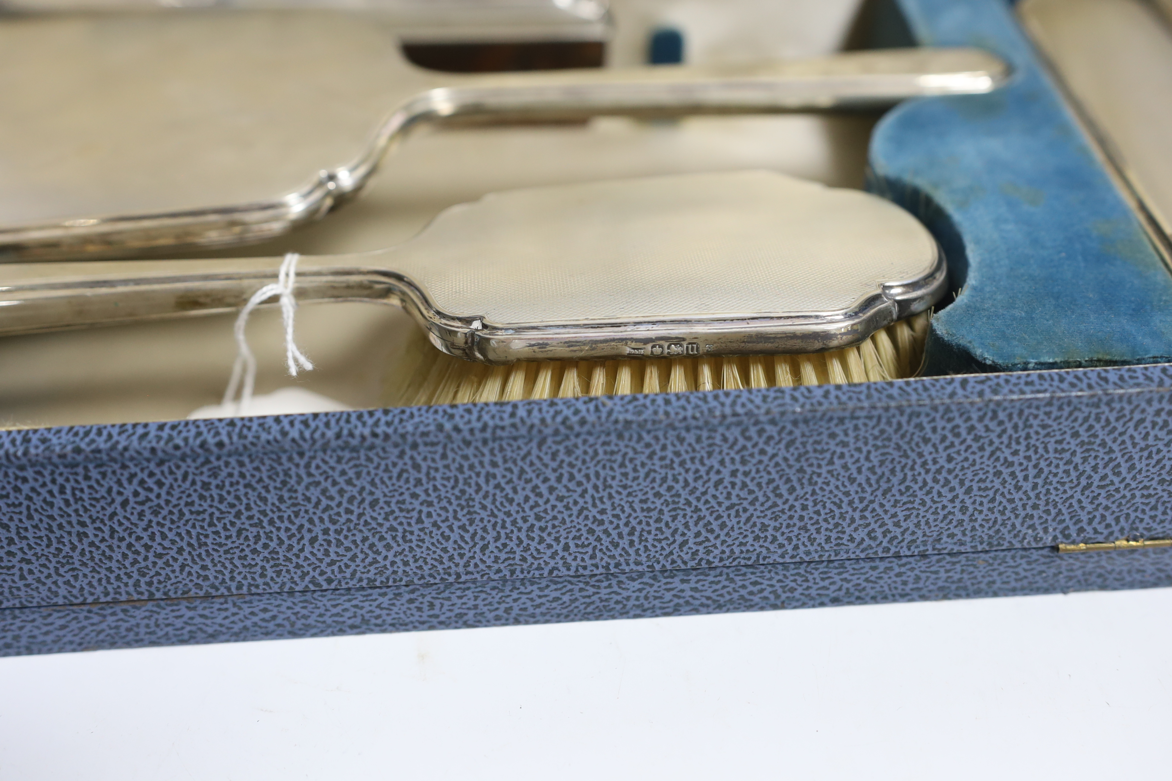 A cased George VI silver mounted four piece dressing table set, by Walker & Hall, Sheffield 1937.